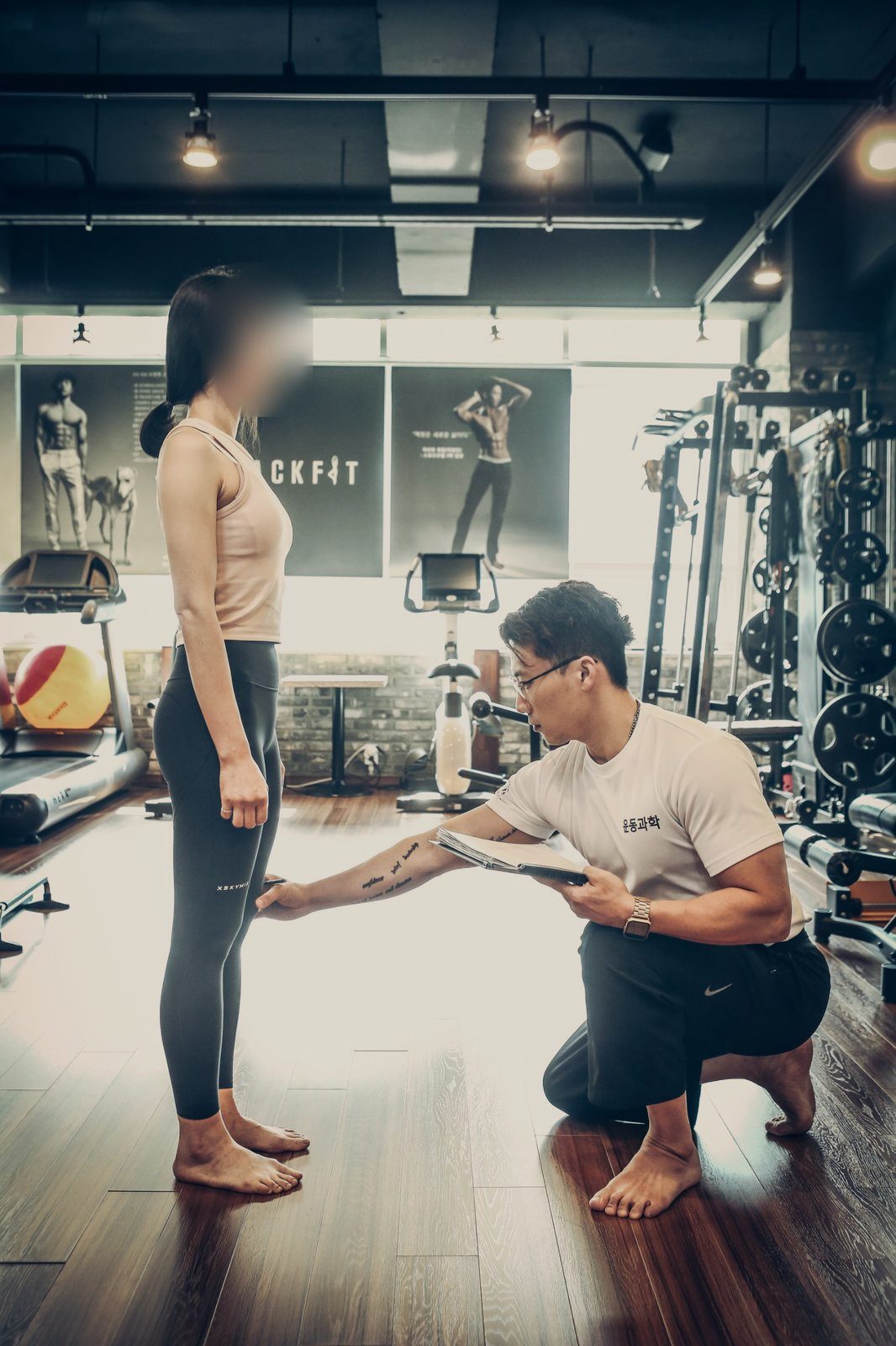 대표원장이 무릎을 꿇고 회원의 다리 정렬을 직접 확인하는 수업 장면